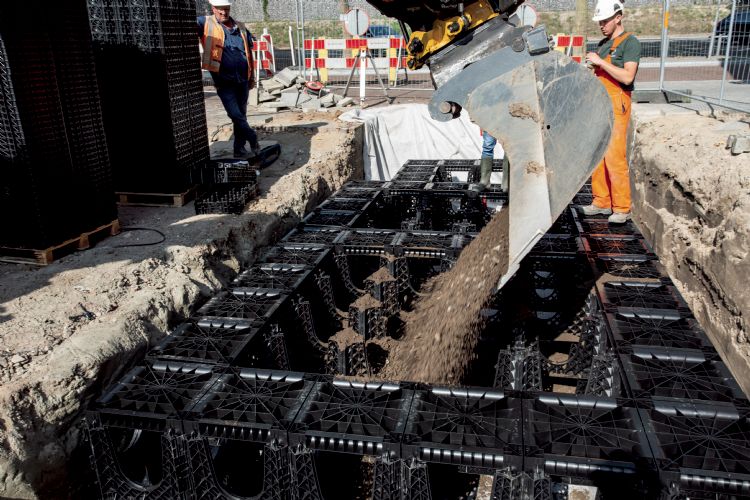 Nadat de aan de randen de deksels zijn geplaatst voor de stabiliteit, wordt de groeiplaats gevuld Nadat de aan de randen de deksels zijn geplaatst voor de stabiliteit, wordt de groeiplaats gevuld